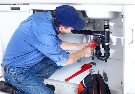 Local plumber clearing a backed-up basement floor drain in Richton Park, IL